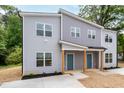 Two-story gray duplex with new landscaping, gray facade, covered entry with wood posts, and blue front doors at 1047 |1049 E Harnett St, Dunn, NC 28334