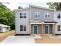 Well-maintained gray duplex with a covered entry, natural wood columns, blue doors, and landscaping at 1047 |1049 E Harnett St, Dunn, NC 28334