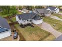 Aerial view of a charming home with a manicured lawn and a two car garage in a quiet neighborhood at 105 Jasper Creek Ct, Wilson's Mills, NC 27520