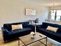 Comfortable living area with blue sofas, neutral walls, and a stylish decor creating a cozy atmosphere at 1129 Kudzu St, Durham, NC 27713