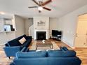 Open-concept living room with a fireplace, modern furniture, and natural light at 1129 Kudzu St, Durham, NC 27713