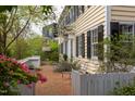 Charming brick patio with seating area, surrounded by white picket fencing and blooming greenery at 1208 College Pl, Raleigh, NC 27605