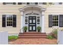 Close-up of the front entrance featuring a black door with white trim and brick steps with the house number 1208 at 1208 College Pl, Raleigh, NC 27605