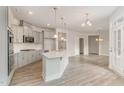 Modern kitchen boasts gray cabinets, an island with a sink, stainless appliances, and an open layout at 1217 Linkwood Way, Fuquay Varina, NC 27526