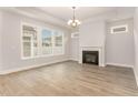 Bright living room featuring a fireplace, hardwood floors, a ceiling fan and large windows for natural light at 1217 Linkwood Way, Fuquay Varina, NC 27526