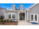 The front of a gray two-story house featuring dormers, a covered entryway, and meticulously maintained landscaping at 153 Tennyson Dr # 235, Garner, NC 27529