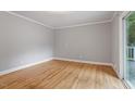 Bright bedroom with hardwood floors and sliding door access to a private balcony at 1615 Malta Ave, Raleigh, NC 27610