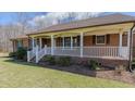 Charming red brick ranch-style home with white front porch and a well-maintained landscape at 1635 Sandy Cross Rd, Burlington, NC 27217