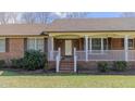 Close-up of the welcoming front porch with brick stairs on a well-maintained lawn at 1635 Sandy Cross Rd, Burlington, NC 27217