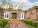 Inviting brick home entrance with a decorative wood door and blue shutters at 21 Kimberly Dr, Durham, NC 27707