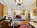 Open-concept living space with hardwood floors, piano, and view into the dining room at 21 Kimberly Dr, Durham, NC 27707