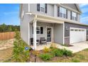 Charming two-story home with gray siding, a welcoming front porch, and a well-manicured front yard at 211 Tobacco Barn Dr, Angier, NC 27501