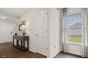 Hallway featuring hardwood floors, a white door and a window with white curtains at 2152 Monk Dr, Haw River, NC 27258