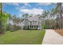 Spacious home with a long driveway and verdant lawn, surrounded by towering trees at 2408 Merion Creek Dr, Apex, NC 27539