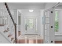 Bright foyer with tile flooring, a staircase and a door with sidelight windows at 2408 Merion Creek Dr, Apex, NC 27539