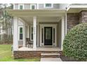 Covered porch features stone accents, white columns, and a cozy seating area at 2408 Merion Creek Dr, Apex, NC 27539