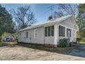 Side view of a cozy home featuring a screened porch and durable gray siding, perfect for easy maintenance at 257 E Raleigh Blvd, Rocky Mount, NC 27801