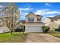 Charming two-story home boasts a manicured lawn and attached two-car garage at 2604 Smoky Topaz Ln, Raleigh, NC 27610