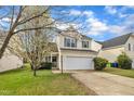 Charming two-story home boasts a manicured lawn and attached two-car garage at 2604 Smoky Topaz Ln, Raleigh, NC 27610