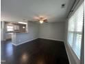Open concept living room with hardwood floors, ceiling fan, and kitchen view at 27 Belmont Ct, Lillington, NC 27546