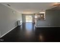 Bright living room with open floor plan, hardwood floors, and view to outdoor deck at 27 Belmont Ct, Lillington, NC 27546