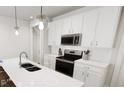 Modern kitchen with white cabinets, stainless steel appliances, and a stylish island with breakfast bar seating at 817 Central Pk Dr, Raleigh, NC 27604