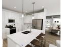Bright kitchen features white cabinetry, stainless steel appliances, an island with seating, and pendant lighting at 817 Central Pk Dr, Raleigh, NC 27604