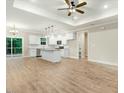 Open-concept living space with modern lighting, hardwood floors, and a stylish kitchen with an island at 303 Cherrybirch Ln, Zebulon, NC 27597