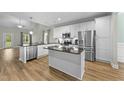 Spacious kitchen boasting white cabinets, stainless steel appliances, and a large island with granite countertops at 396 Martins Mill Ct, Wendell, NC 27591