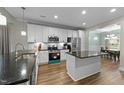 Modern kitchen with white cabinets, stainless steel appliances, a kitchen island and beautiful countertops at 396 Martins Mill Ct, Wendell, NC 27591