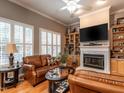 Cozy living room with hardwood floors, built-in shelving, a fireplace, and plush leather seating at 4203 Norman Ridge Ln, Raleigh, NC 27613