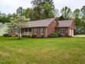 Well-maintained brick home with lush lawn, detailed landscaping, and attached garage at 422 Old Scarborough Ln, Garner, NC 27529