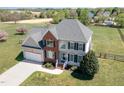 Spacious two-story home with attached garage on a large lot surrounded by a white fence at 4905 Homestead Dr, Mebane, NC 27302