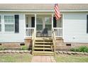 Inviting front porch with white railings, seating, and an American flag waving proudly at 660 Our Way, Linden, NC 28356