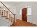 Welcoming foyer with hardwood floors, a staircase, and a front door with sidelights at 7002 Old Trail Dr, Durham, NC 27712