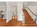 Elegant foyer featuring hardwood floors, a staircase, and chandelier lighting at 7002 Old Trail Dr, Durham, NC 27712
