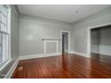 Cozy living room with hardwood floors, white trim, neutral paint, and a decorative fireplace at 703 Cokey Rd, Rocky Mount, NC 27801