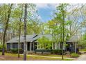 Beautiful one story house with a gray roof and siding surrounded by lovely trees at 706 Kensington Dr, Chapel Hill, NC 27514