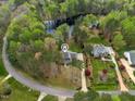 Aerial view of a residential neighborhood with mature trees, lawns, and a lake nearby at 7336 Barham Hollow Dr, Wake Forest, NC 27587
