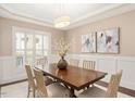 Elegant dining room with hardwood floors, wainscoting, neutral walls, and a modern light fixture at 800 Laurel Garden Way, Cary, NC 27513
