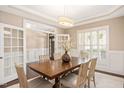 Bright dining room with hardwood floors, large windows, and a wooden table set for six at 800 Laurel Garden Way, Cary, NC 27513