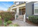 Inviting front porch with stone steps, white railings, and a charming wooden front door with a wreath at 800 Laurel Garden Way, Cary, NC 27513