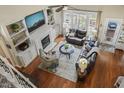 Bright living room featuring hardwood floors, fireplace, and large windows with backyard views at 8308 Buck Crossing Dr, Durham, NC 27713
