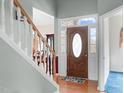 Bright entryway with wood floors, a staircase and front door with transom window at 1008 Double Spring Ct, Apex, NC 27502