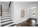 Bright foyer with wooden stairs, hardwood floors, and stylish decor that create a welcoming atmosphere at 105 Smoky Emerald Way, Holly Springs, NC 27540
