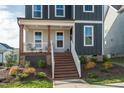 Close-up of a home's inviting front porch with wooden steps and decorative landscaping details at 109 Broadwater Dr, Wake Forest, NC 27587