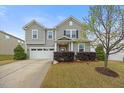 Traditional two-story home with a well-maintained lawn, tidy bushes, and a two-car garage on a sunny day at 109 Oak Rise Ln, Fuquay Varina, NC 27526