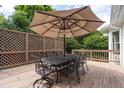 Outdoor deck with an outdoor dining table and large shade umbrella at 109 Yorkchester Way, Raleigh, NC 27615
