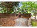 Private backyard with brick fireplace, patio, and mature landscaping at 1104 Hobson Ct, Raleigh, NC 27607