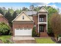 Charming two-story brick home with a two-car garage, covered porch, and manicured lawn at 1104 Hobson Ct, Raleigh, NC 27607